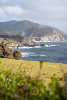 A breathtaking view of Big Sur coastline with Bixby Creek Bridge and rolling hills in California.