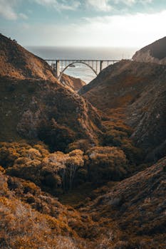 Stunning landscape of Bixby Bridge in Big Sur with rugged hills and a scenic ocean view.