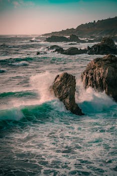 Stunning view of waves crashing against rocks on Big Sur coastline, California.
