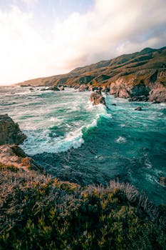 Stunning seascape of Big Sur, with rugged cliffs, rolling waves, and dramatic skies.