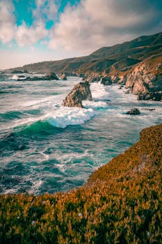 Beautiful coastal landscape of Big Sur with crashing waves and rocky shore in California.