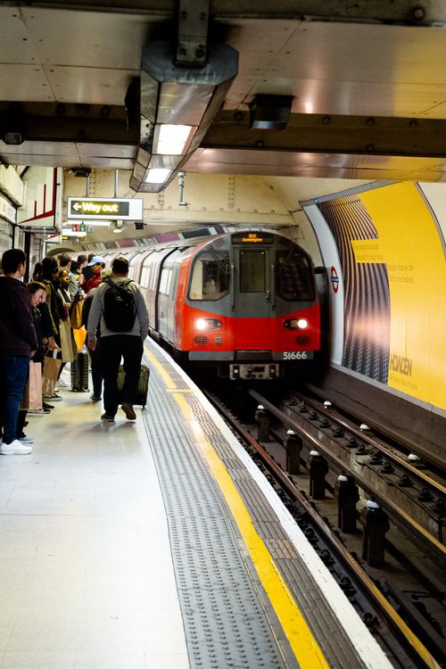 Free Passengers wait for a train at a bustling underground station in the city. Stock Photo