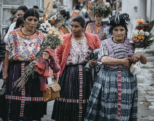 Free Women in traditional Guatemalan clothing gather with flowers, celebrating a cultural festival. Stock Photo
