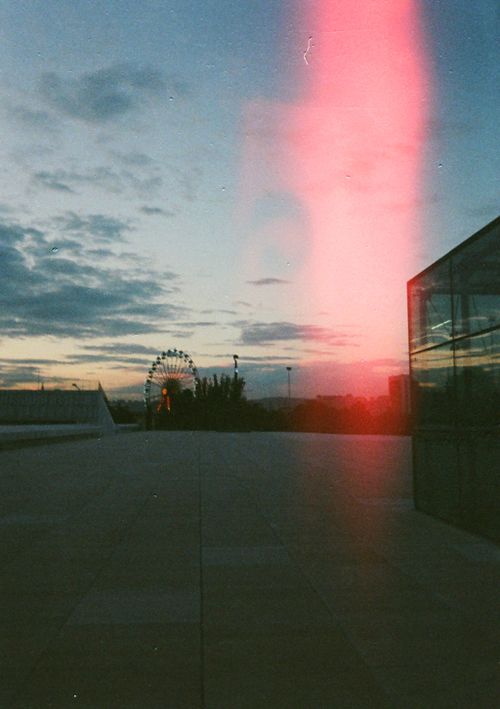 Free Analog photo of an urban sunset scene featuring a Ferris wheel with a light leak effect. Stock Photo
