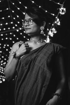 Portrait of a woman in traditional Indian attire surrounded by string lights, capturing cultural essence and elegance.