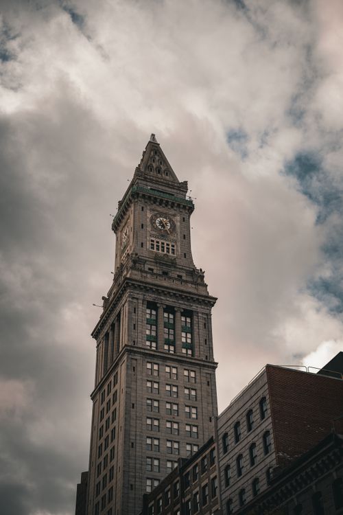 Free Capture of Boston's iconic Custom House Tower against a dramatic cloudy sky, showcasing its timeless architecture. Stock Photo