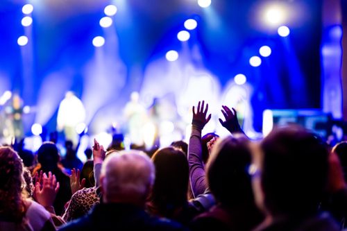 Free Energetic crowd enjoying a music concert under vibrant stage lights, capturing the spirit of live performance. Stock Photo
