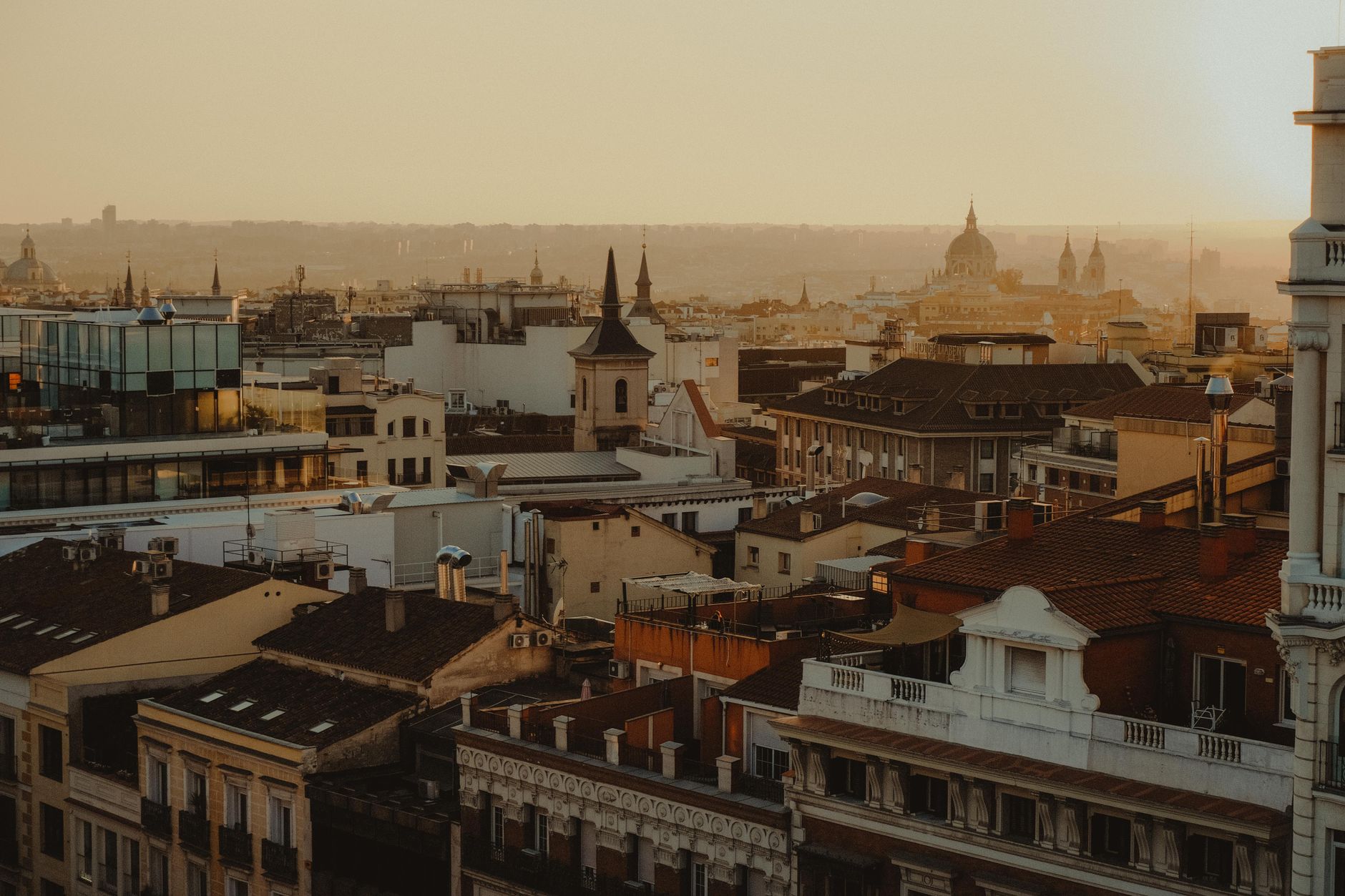 Scenic panorama of Madrid's rooftops and skyline at sunset.