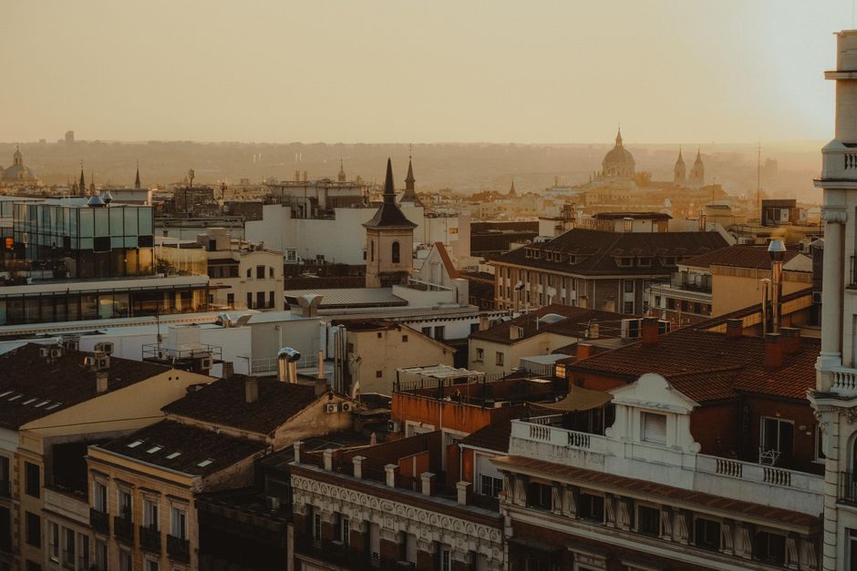 Scenic panorama of Madrid's rooftops and skyline at sunset.