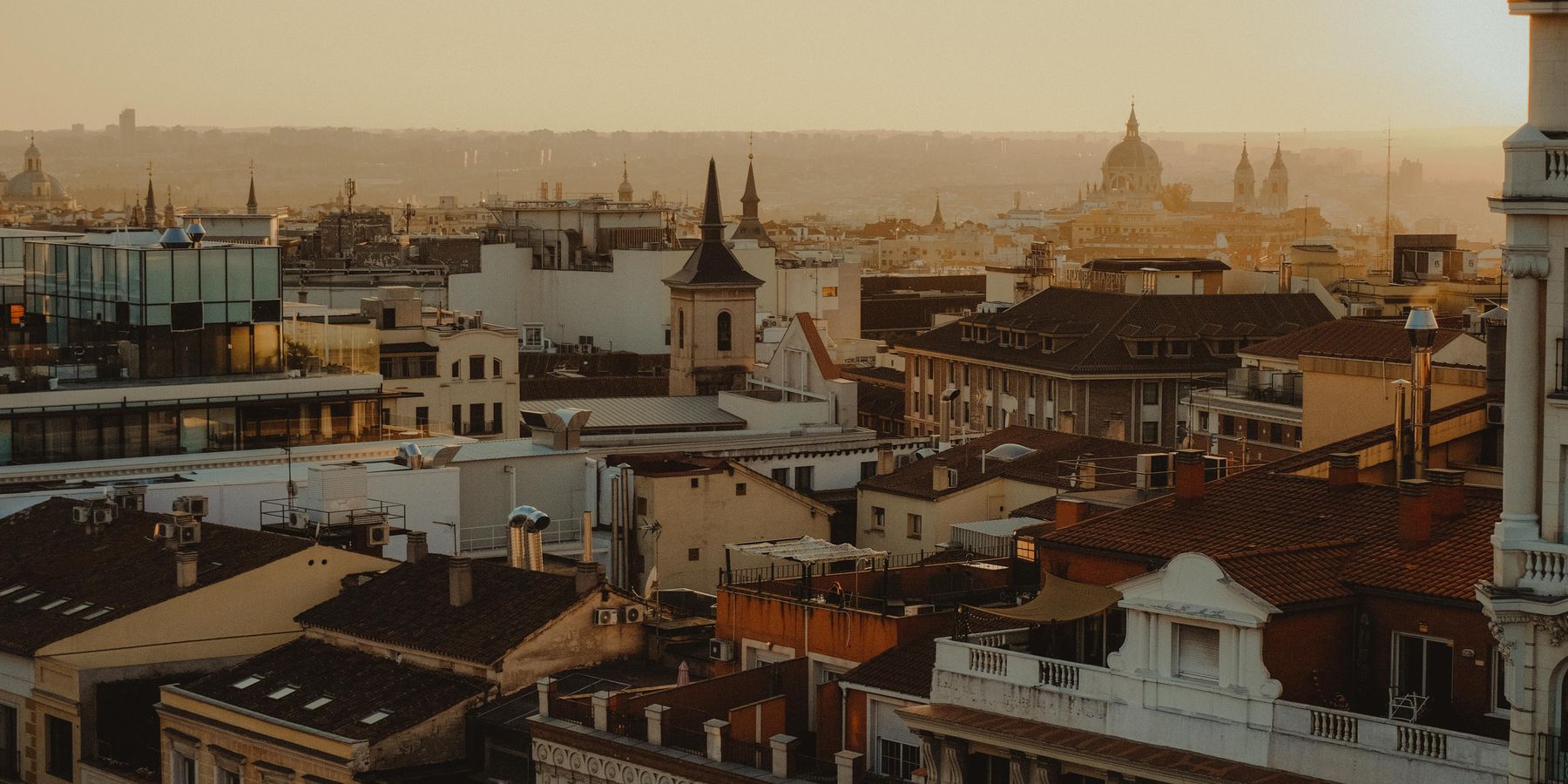 Scenic panorama of Madrid's rooftops and skyline at sunset.