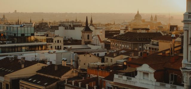 Scenic panorama of Madrid's rooftops and skyline at sunset.