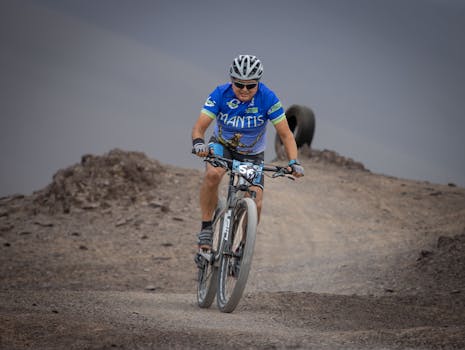 Adult male cyclist racing on a rugged mountain trail. Adventure sport in the wilderness.