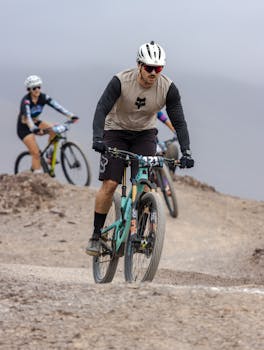Intense mountain biking scene with cyclists racing on a challenging trail, showcasing endurance and adventure.