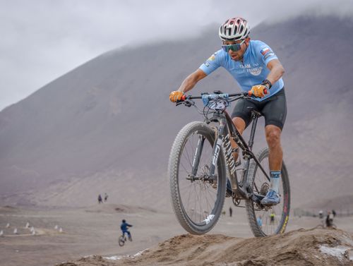 Free Cyclist navigating rocky trail in fog; wearing safety gear during a mountain bike race. Stock Photo