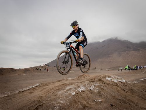 Free A mountain biker jumps over a trail in a desert race, showcasing skill and adrenaline. Stock Photo