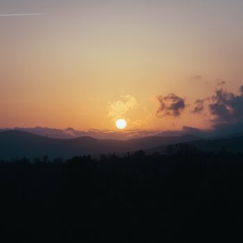 Captivating sunset view with mountains and clouds, perfect serene nature scene.