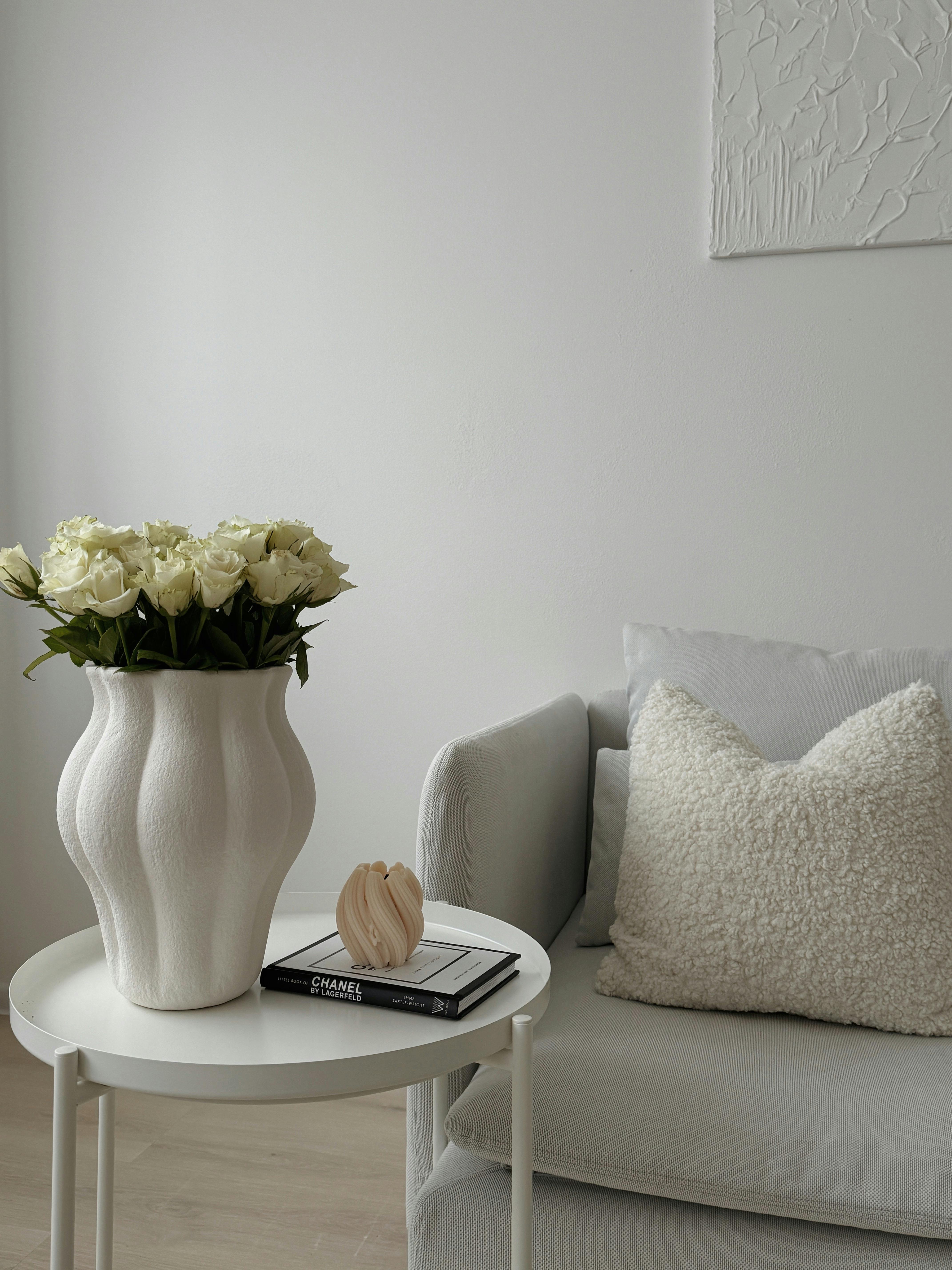 porcelain vase full of roses on a coffee table next to a white couch