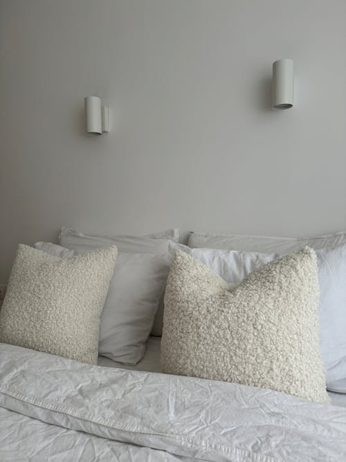 Bed with Pillows in White Faux Fur Covers