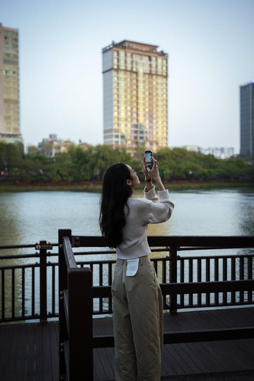 Young Woman Taking Pictures with a Smartphone in City 