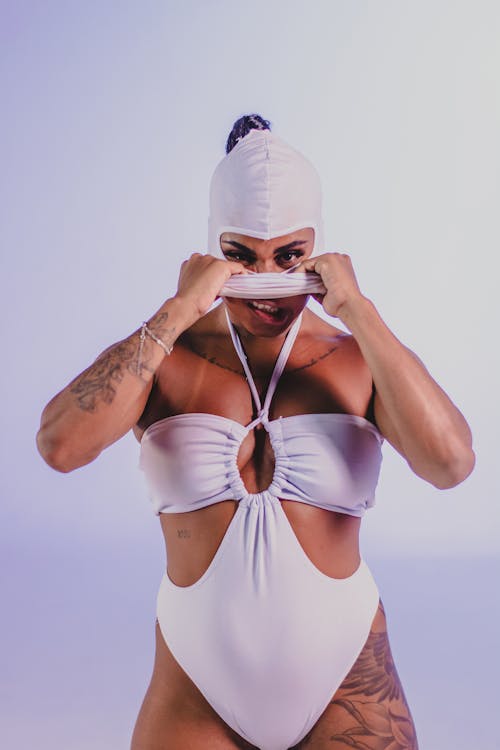 Woman in a White Swimsuit Putting on a Swim Cap 