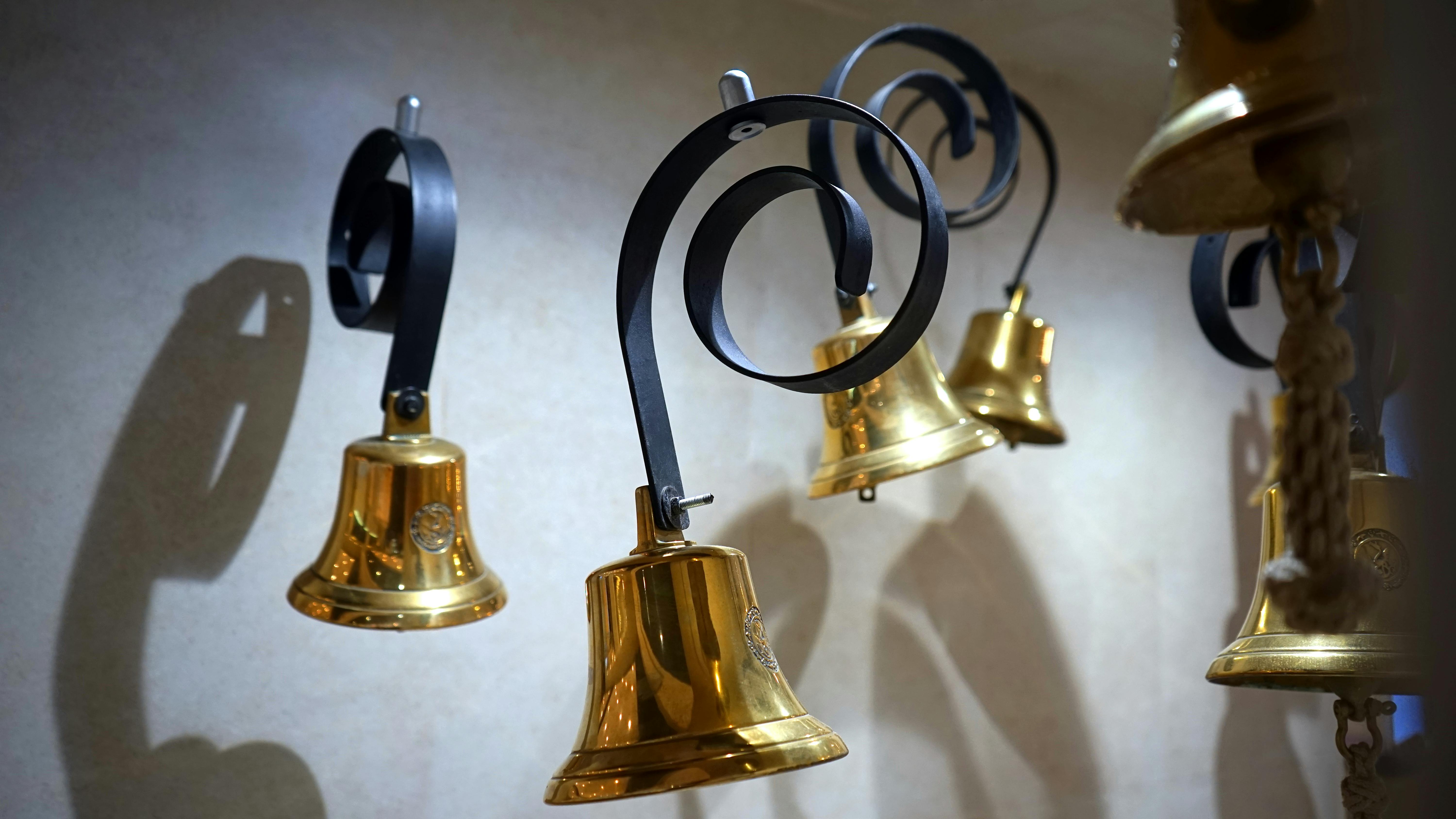 gold colored and black hanging bells near wall