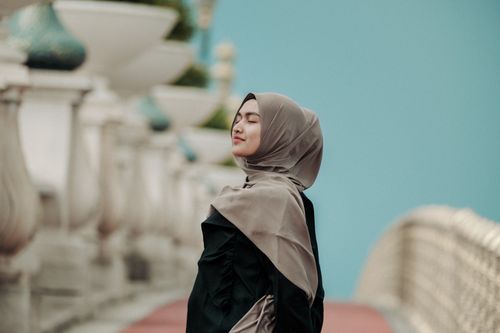 Free A young woman wearing a hijab, enjoying the outdoors on a bridge in Putrajaya, Malaysia. Stock Photo