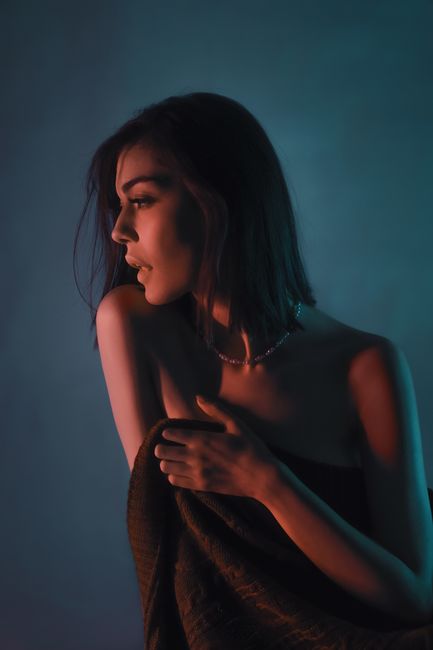 Artistic portrait of a woman in creative studio lighting, evoking emotion and depth.