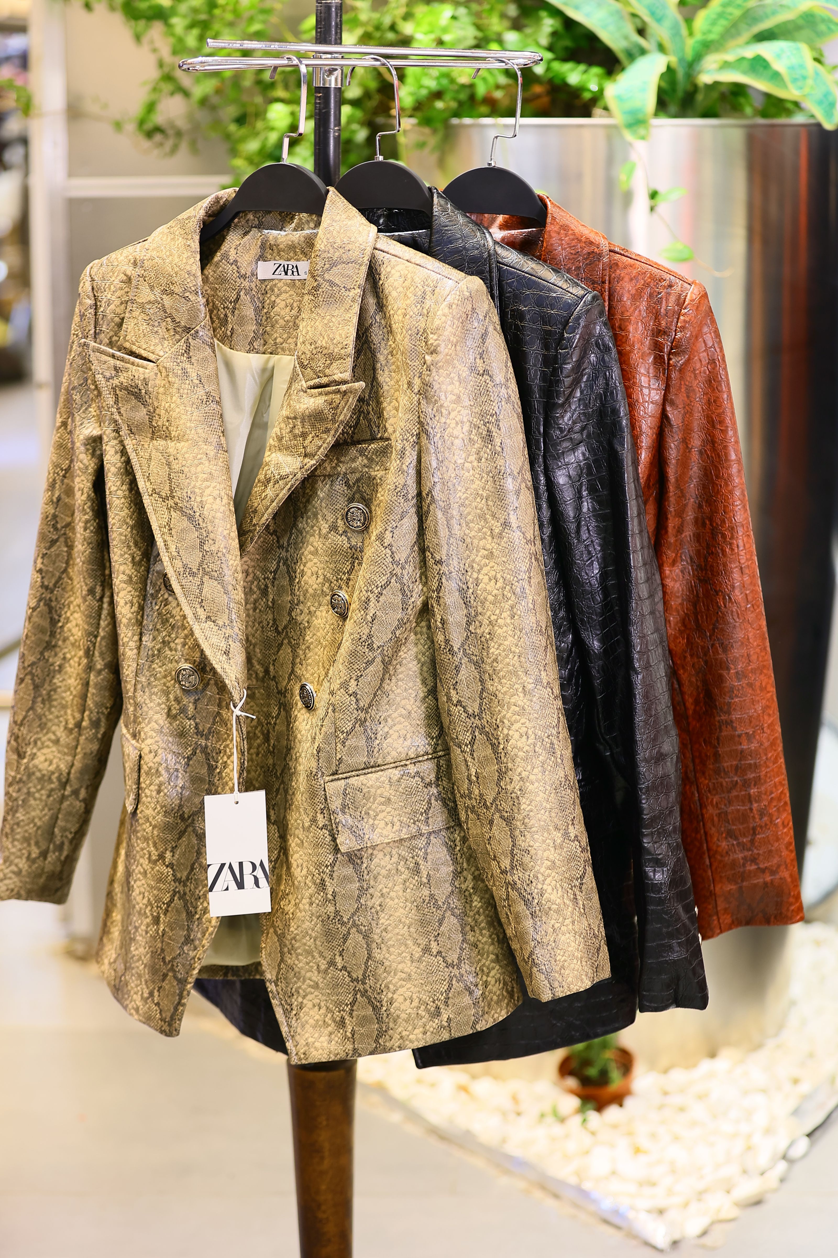 Blazers estilizados com padrão de cobra elegantemente exibidos em uma boutique de moda. Perfeitos para estilos modernos.