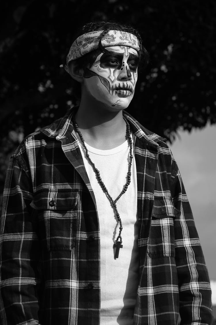 Black And White Photo Of A Man With Sugar Skull Makeup Wearing A Checkered Shirt 