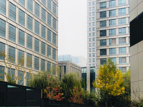 Free Contemporary urban scene in Tianjin, China showcasing modern architecture amidst autumn foliage. Stock Photo