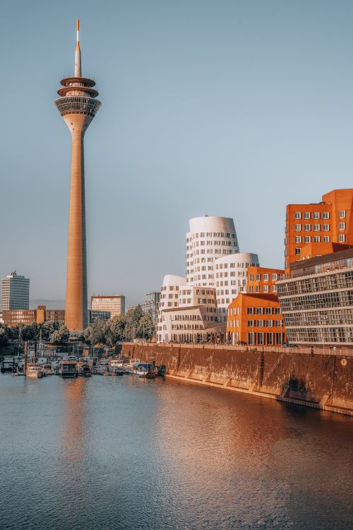 Free Düsseldorf's iconic Rheinturm and Media Harbor captured under clear skies. Urban architecture at its finest. Stock Photo