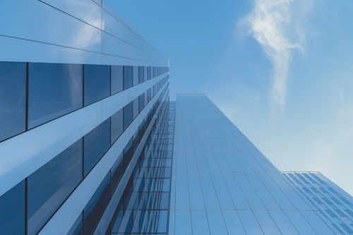 Free Elegant glass skyscraper reaching into a clear blue sky, modern architecture. Stock Photo