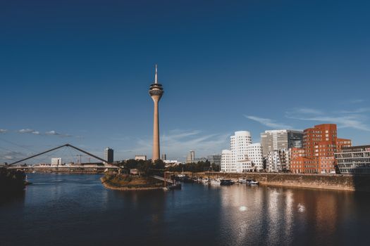 Stunning view of Düsseldorf with Rheinturm and modern architecture reflected in the Rhine River.