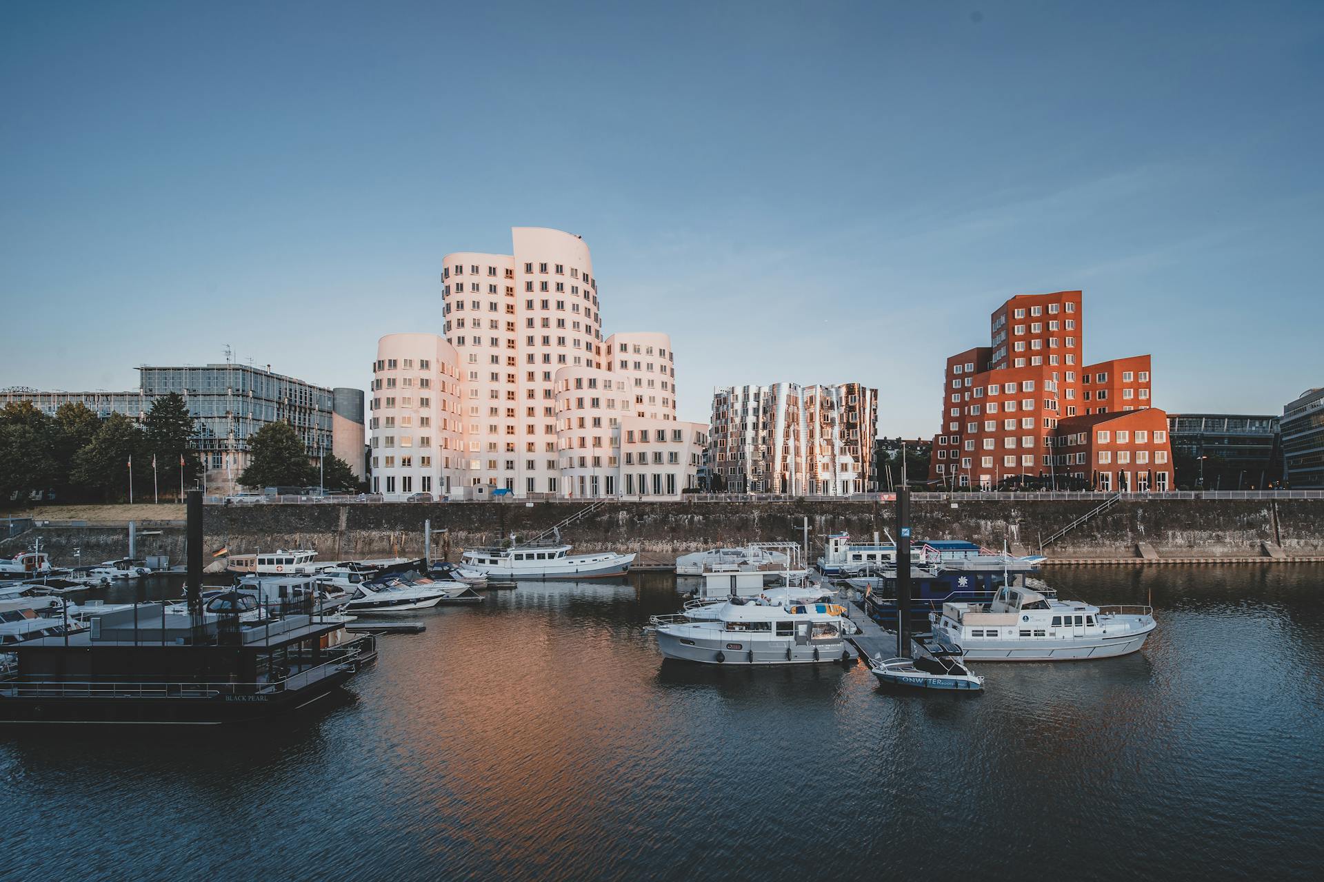Stunning view of Düsseldorf's Rhine River marina with iconic Gehry architecture at Neuer Zollhof.