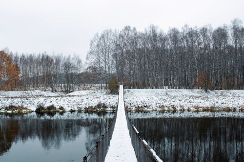 Free A serene winter scene with a snow-covered footbridge over a river in Dorokhovo, Russia. Stock Photo