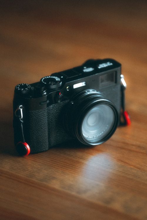 Free Classic retro camera on a wooden table with soft lighting for a nostalgic feel. Stock Photo