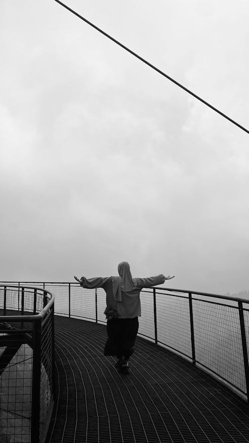 Back View of a Woman Standing with Arms Spread on an Observation Deck 