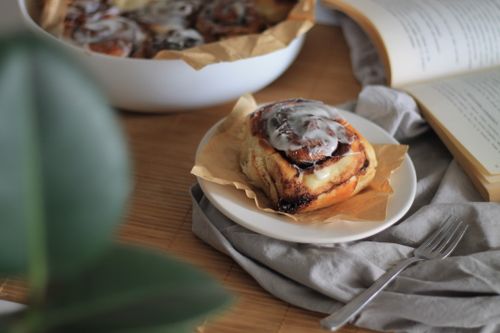 Free Close-up shot of a cinnamon roll with icing, perfect breakfast food on a plate. Stock Photo