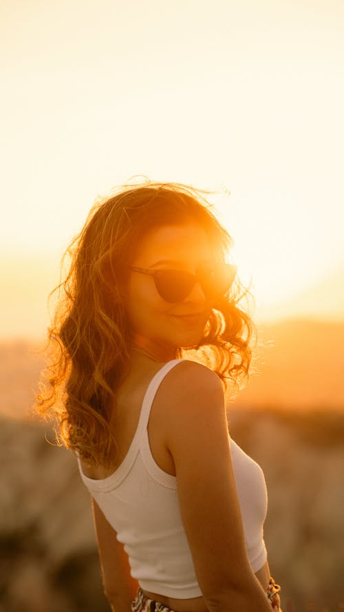 Woman in Sunglasses and White Crop Top Smiling