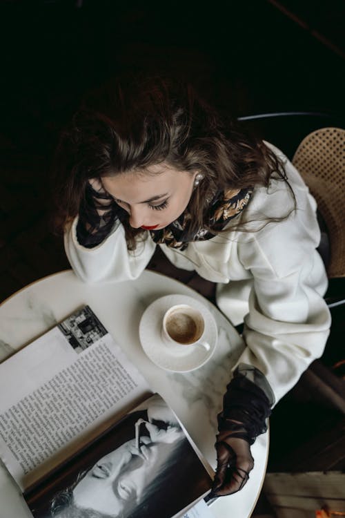 Free Elegant Woman Sitting at the Table with a Coffee and a Magazine Stock Photo