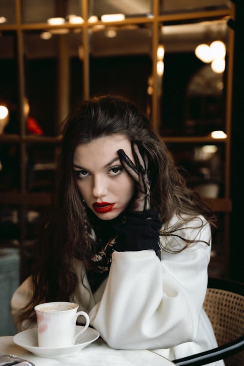 Free Young Woman with Red Lips Sitting at the Table in a Cafe Stock Photo