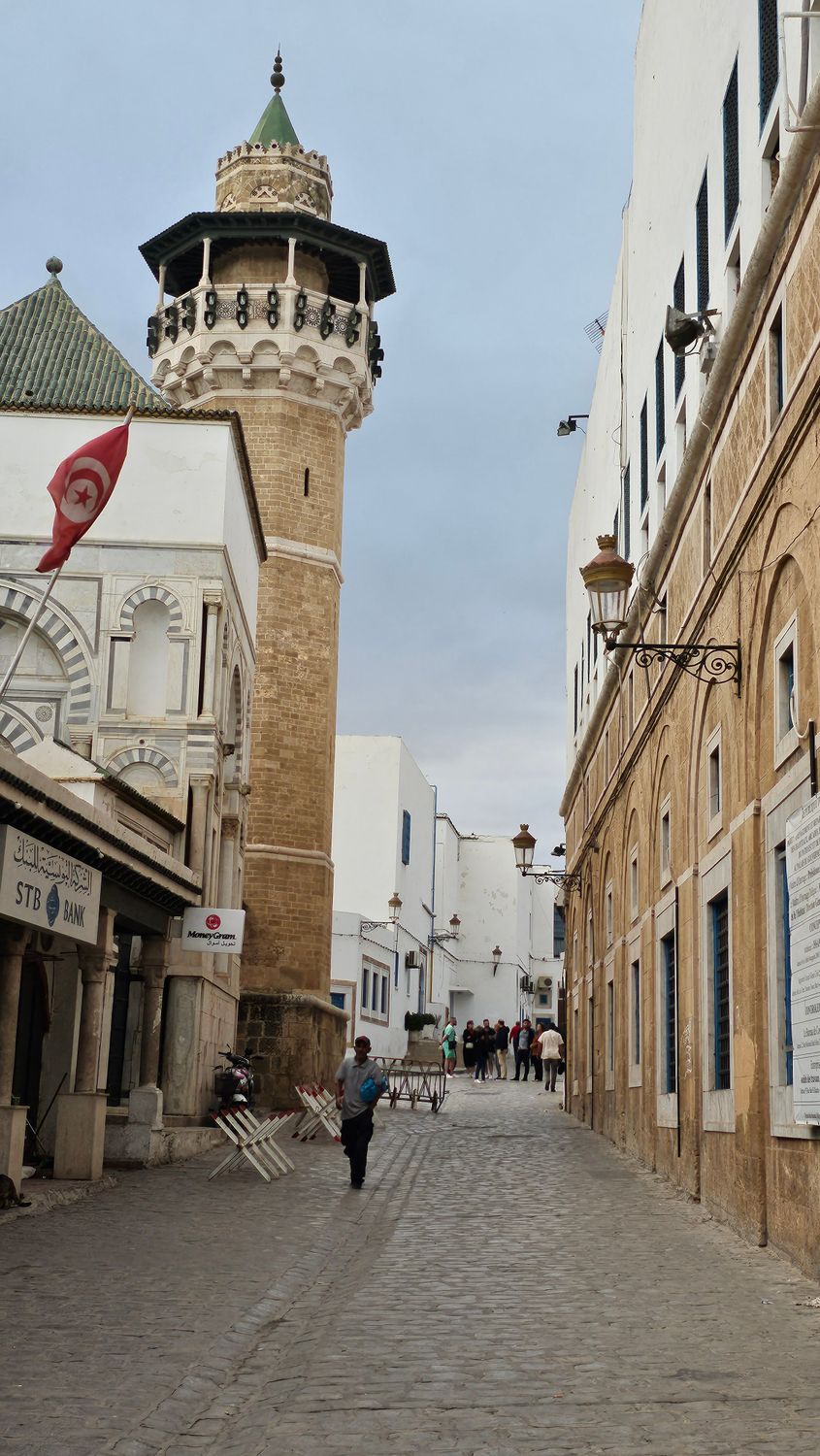 DigitalbyNadas Narrow winding street in a historic Tunisian medina with whitewashed walls