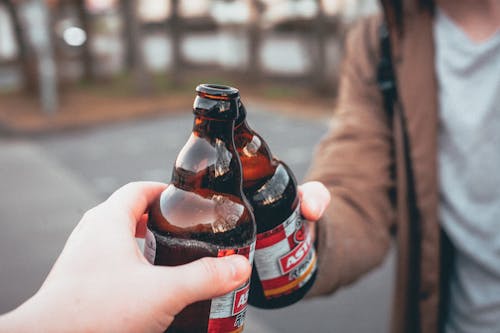 Foto De Foco Raso De Pessoa Segurando Uma Garrafa De Cerveja