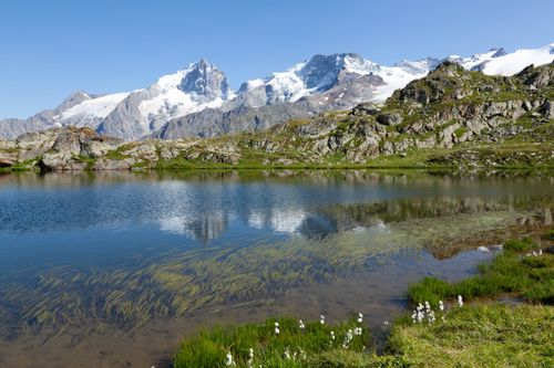 Free Picturesque view of an alpine lake with snow-capped mountains in La Grave, France. Stock Photo