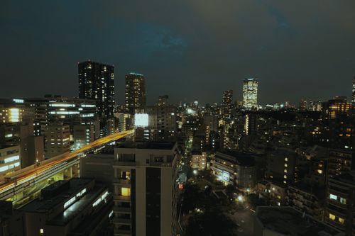 Free Aerial view of a vibrant cityscape at night with illuminated skyscrapers and buildings, showcasing urban architecture. Stock Photo