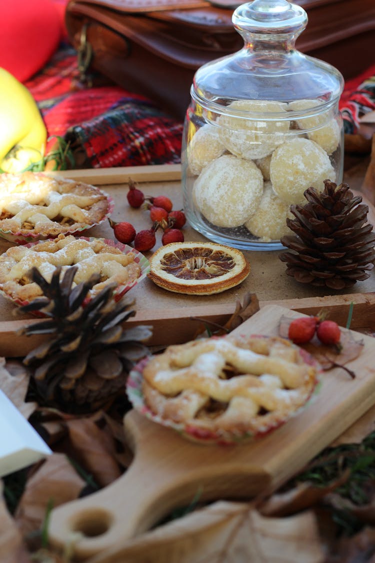 Christmas Pies On Cutting Boards Among Fruits, Sweets And Cones