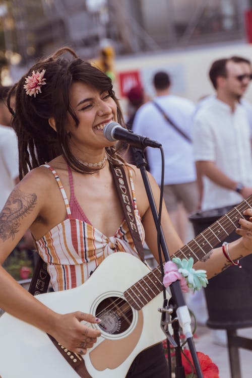 Young Woman Singing and Playing the Guitar at a Music Festival 