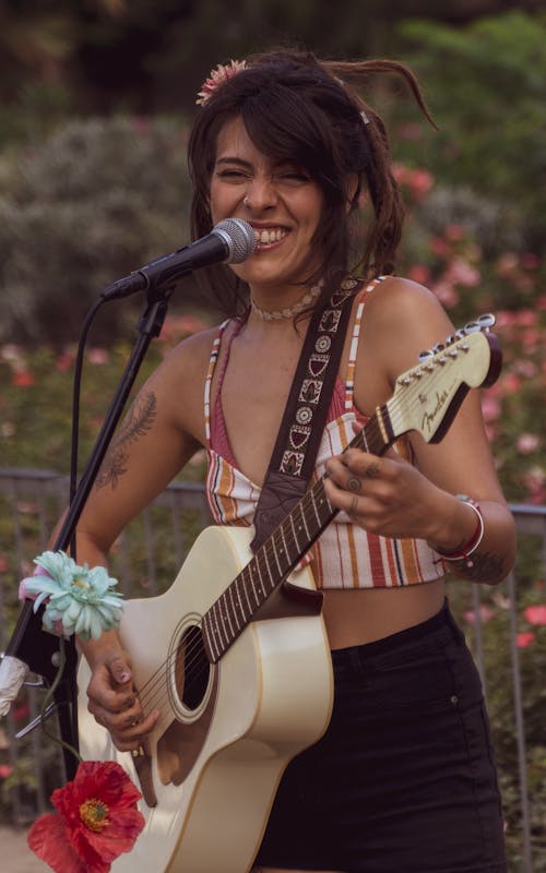 Woman Playing the Guitar and Singing 