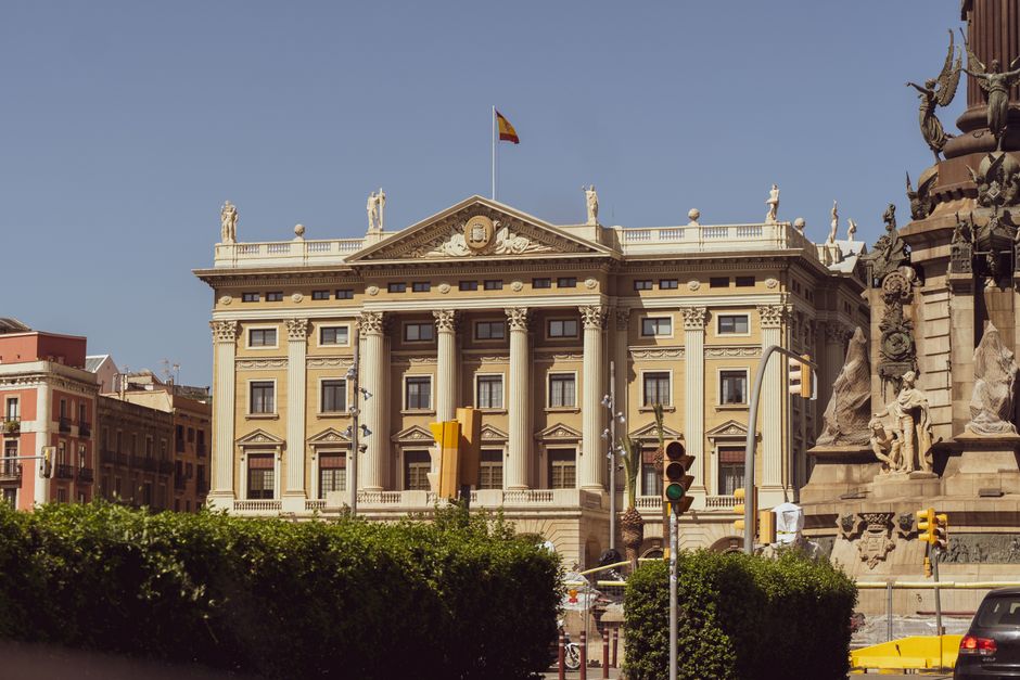 Fachada neoclásica histórica con columnas en Barcelona contra un cielo despejado.