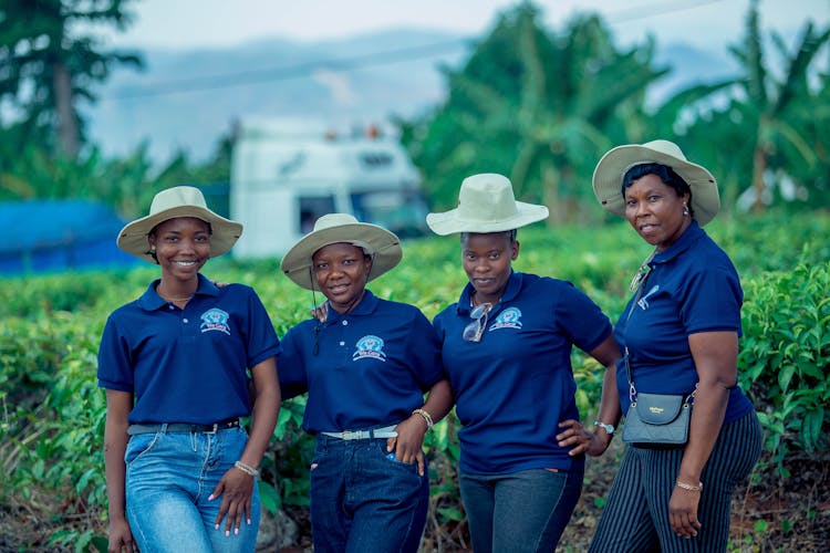 A Group Of Women Wearing The Same T-shirts And Hats Standing Outside 